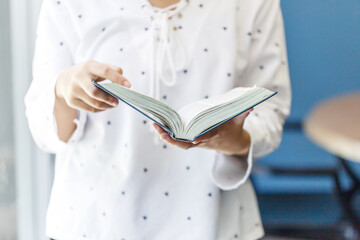 Young woman reading book in the house