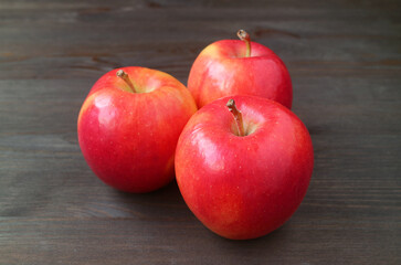 Closeup heap of fresh ripe red apple isolated on black wooden backdrop