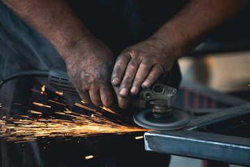 Close up on a man held an angle grinder to cut an iron with sparks