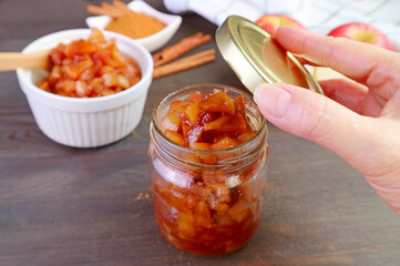 Delectable homemade caramelized apple cinnamon compote being stored in glass jar