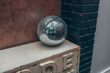 The disco ball is on the shelf. A decorative object in the interior. The interior of a nightclub and a bar. A reflecting ball.