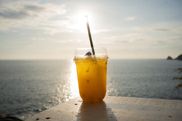 glass of orange juice on beach