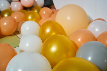 Many different inflatable festive balls lying on the floor in yellow tones