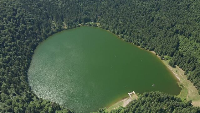 4K drone view over the beautiful landscape of Saint Anna (in Romanian Sfanta Ana) volcanic crater lake in the mountains of Transylvania. Travel to Romania.