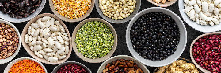 Banner of different types of legumes in bowls, green with yellow peas and mung beans, chickpeas and...