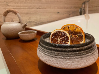Dried oranges in bowl of bath salts with tea set landscape