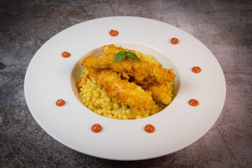 Recipe for chicken tenders with corn flakes and Italian Piombo pasta risotto and peppers. High quality photo