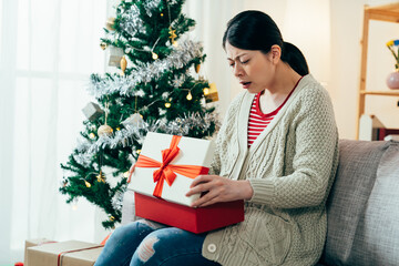 portrait woman is feeling bad about getting unwanted Christmas gift from husband. asian millennial...