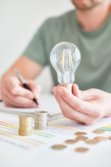 Mann am Schreibtisch macht Berechnungen zum Thema Sparen, Energie, Heizkosten und Umwelt