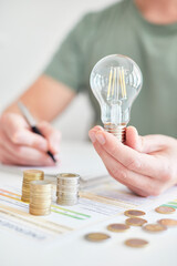 Mann am Schreibtisch macht Berechnungen zum Thema Sparen, Energie, Heizkosten und Umwelt