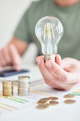 Mann am Schreibtisch macht Berechnungen zum Thema Sparen, Energie, Heizkosten und Umwelt