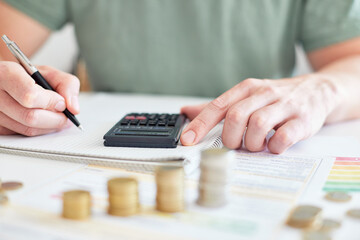 Mann am Schreibtisch macht Berechnungen zum Thema Sparen, Energie, Heizkosten und Umwelt