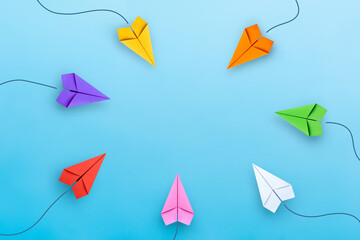 Set of multiple colorful paper planes on blue background with copy space