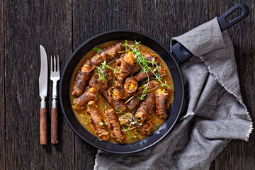 german beef rouladen in thick gravy on pan