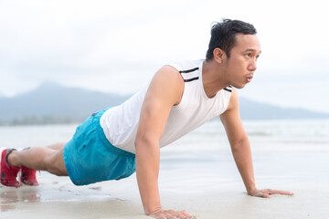 Healthy lifestyle. asian sportman doing sports exercises at the beach. working out on a road by the sea