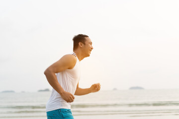 asian sport man running along seaside. running on beach with healthy toned legs body, Hamstring muscles, knee joint health active lifestyle panoramic banner background. the beach runners working out