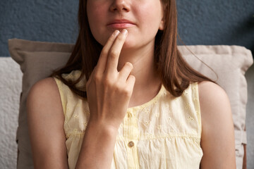Teenage girl practicing EFT or Emotional freedom technique - tapping on the chin point