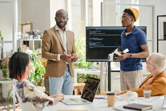 Group of programmers testing new software for virtual reality glasses during teamwork at meeting