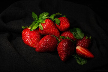 large ripe strawberries lying on a dark table with a black napkin