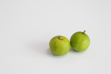 two fresh green lime on a white table