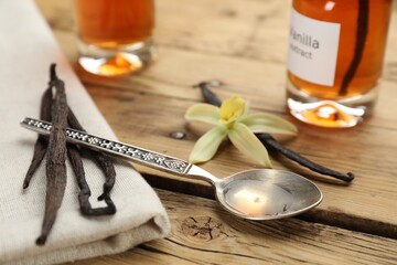 Aromatic vanilla extract and beans on wooden table