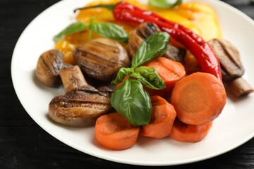 Delicious grilled vegetables with basil on plate, closeup