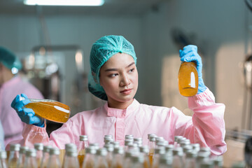 Asian woman worker checking product bottles basil seed with fruit on shelf pallet parcel in the beverage factory. Manufacturer and Inspection quality control
