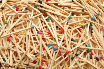 Matches with colorful heads as background, top view