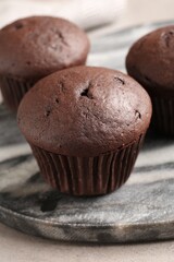 Delicious fresh chocolate cupcakes on grey marble board, closeup
