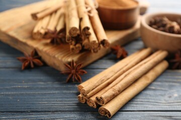 Aromatic cinnamon sticks and anise on blue wooden table
