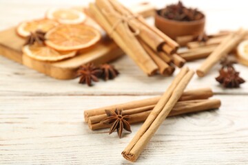 Aromatic cinnamon sticks and anise on white wooden table