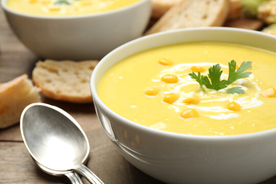 Delicious creamy corn soup served on table, closeup