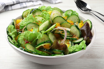 Bowl of delicious cucumber salad on white wooden table, closeup