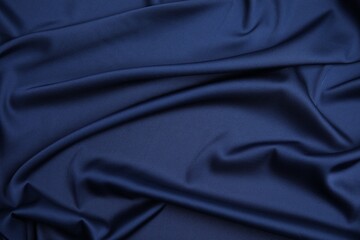 Obraz premium Crumpled dark blue silk fabric as background, top view