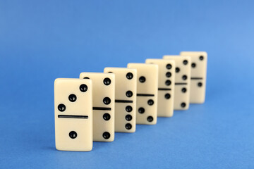 Row of white domino tiles on blue background