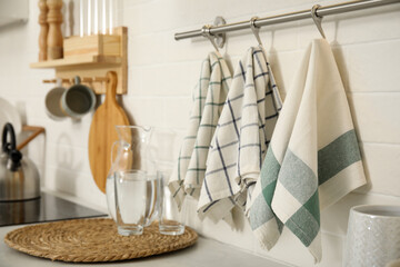 Different clean towels hanging on rack in kitchen