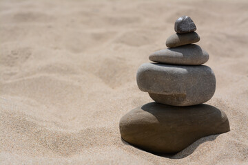 Fototapeta na wymiar Stack of stones on beautiful sandy beach, space for text