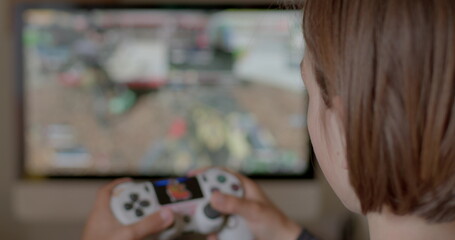 Child plays video games after school, kid spends too much time playing games. Action game can boost cognitive abilities perception, attention, and reaction time. 