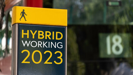 Hybrid working 2023 sign in a busy commuter city center	