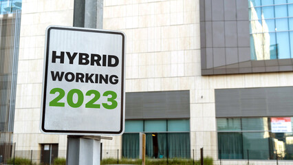 Obraz premium Hybrid working 2023 sign in a downtown city setting 