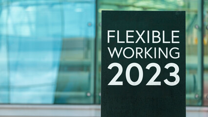 Flexible Working 2023 on a sign outside a modern glass office building	