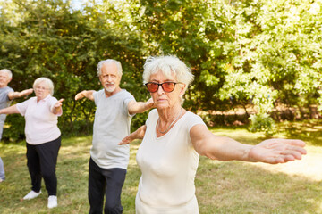 Seniors with stretched arms in gymnastics class