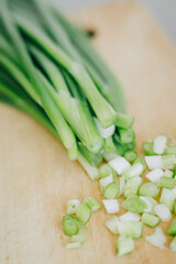 sliced green onions on wooden cutting board and parsley