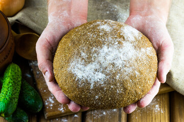 Bakery concept. Close-up view of home baked bread in male hands