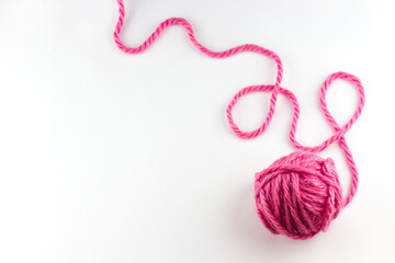 Top view of pink yarn ball with woolen thread on white background 