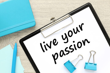 Live your passion a sheet of paper on a folder near a blue notepad. live your dream predestination self motivation coaching concept.