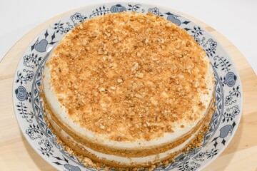 Traditional homemade czech Honey cake (Medovník) with cream and grinded nuts topping 