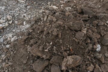 Pile of dark brown construction gardening soil mud land earth dirt heap pile mound, freshly dug