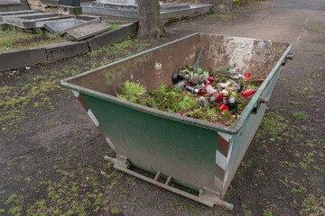 Cemetery waste junk rubbish bin container with candles and flowers