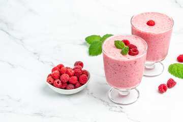 raspberries smoothie milkshake or yogurt in glass jar with berries. Yogurt cocktail on a white background. place for text, top view